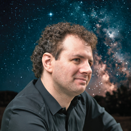 Mann mit lockigem Haar, sichtbar vor einem sternenübersäten Nachthimmel.